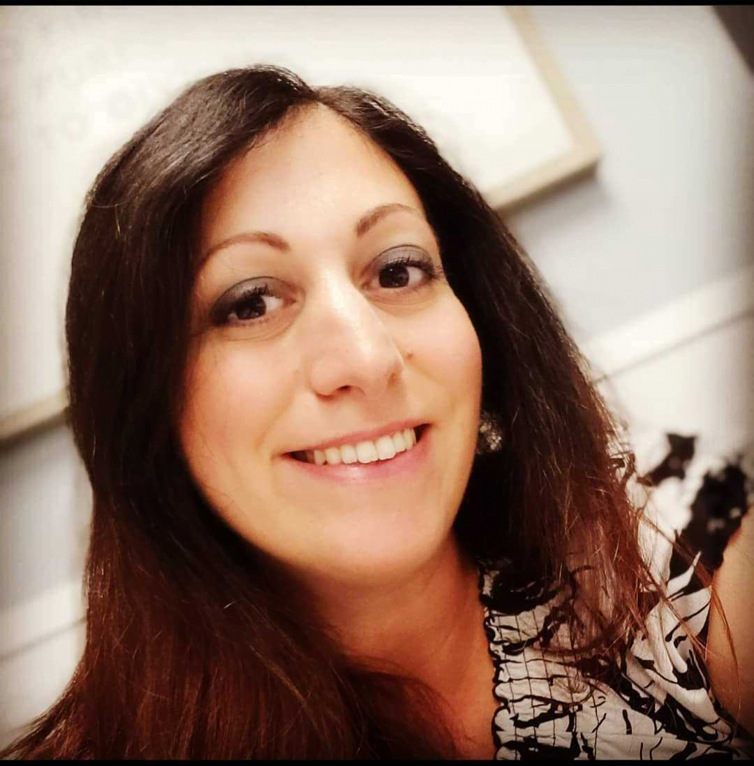Smiling woman with long hair indoors.